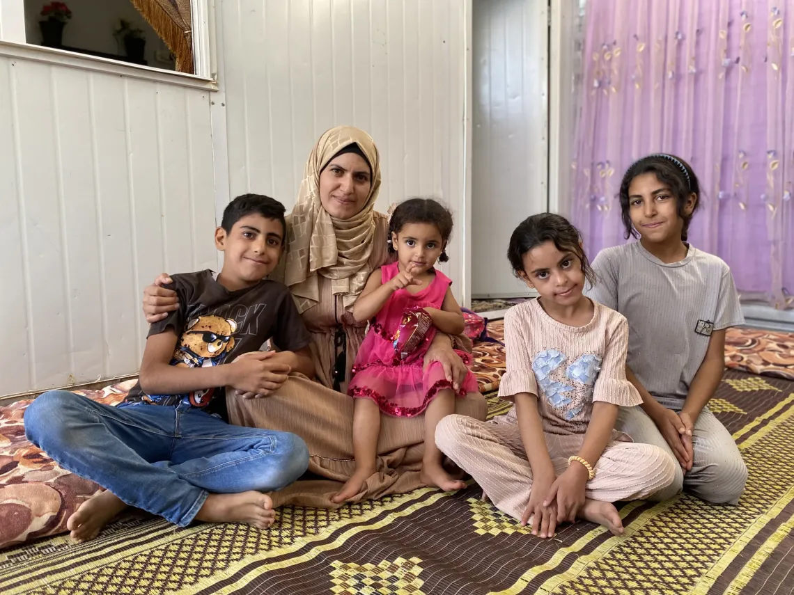 A mother and her children sitting together, smiling.