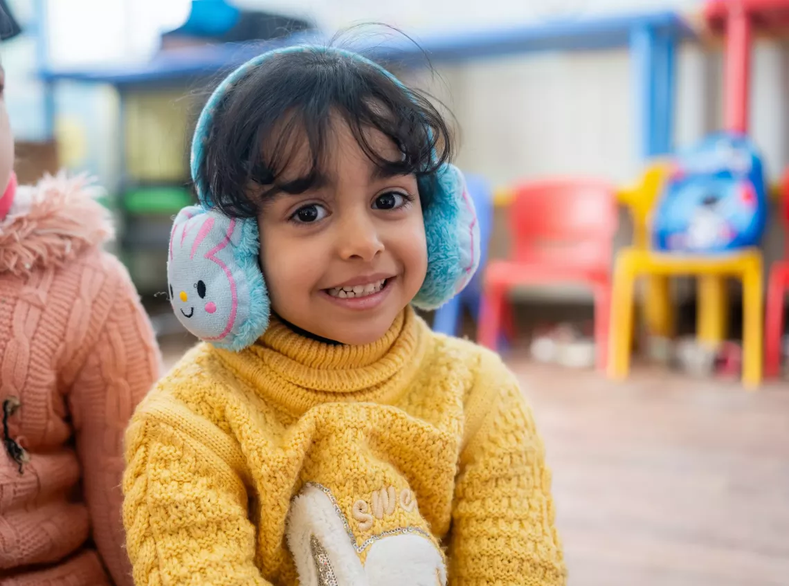 A little girl smiling to the camera.