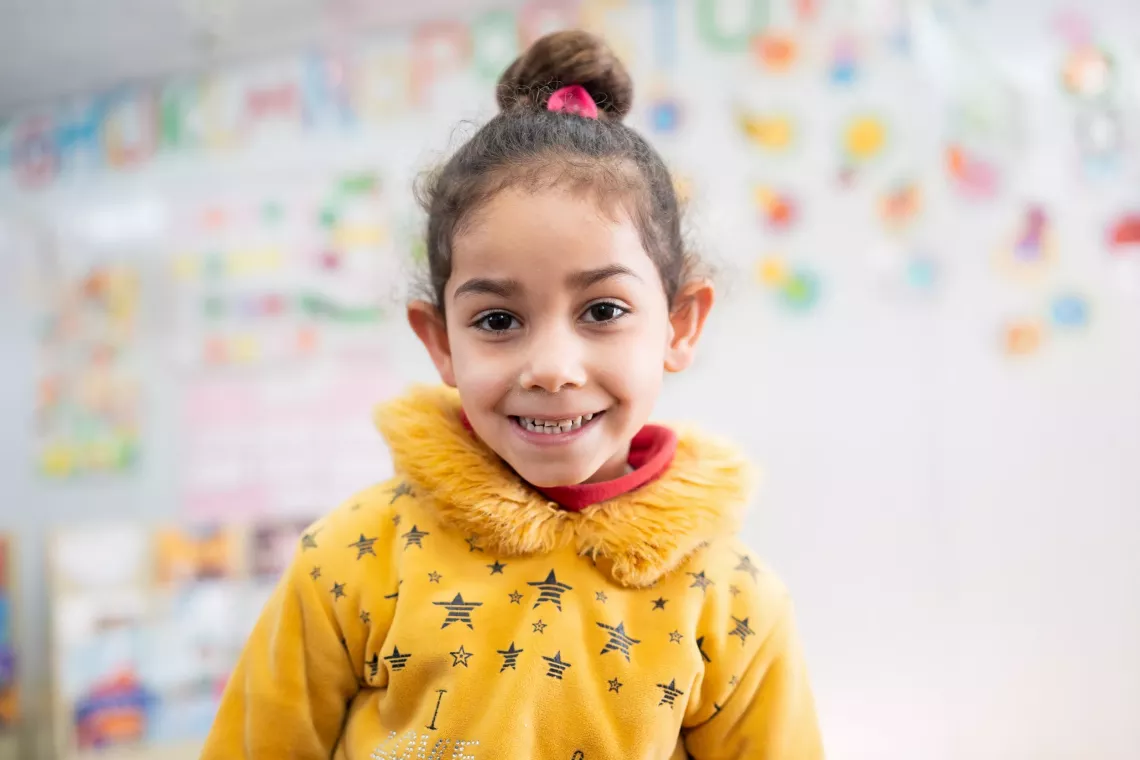 A little girl smiling at the camera.