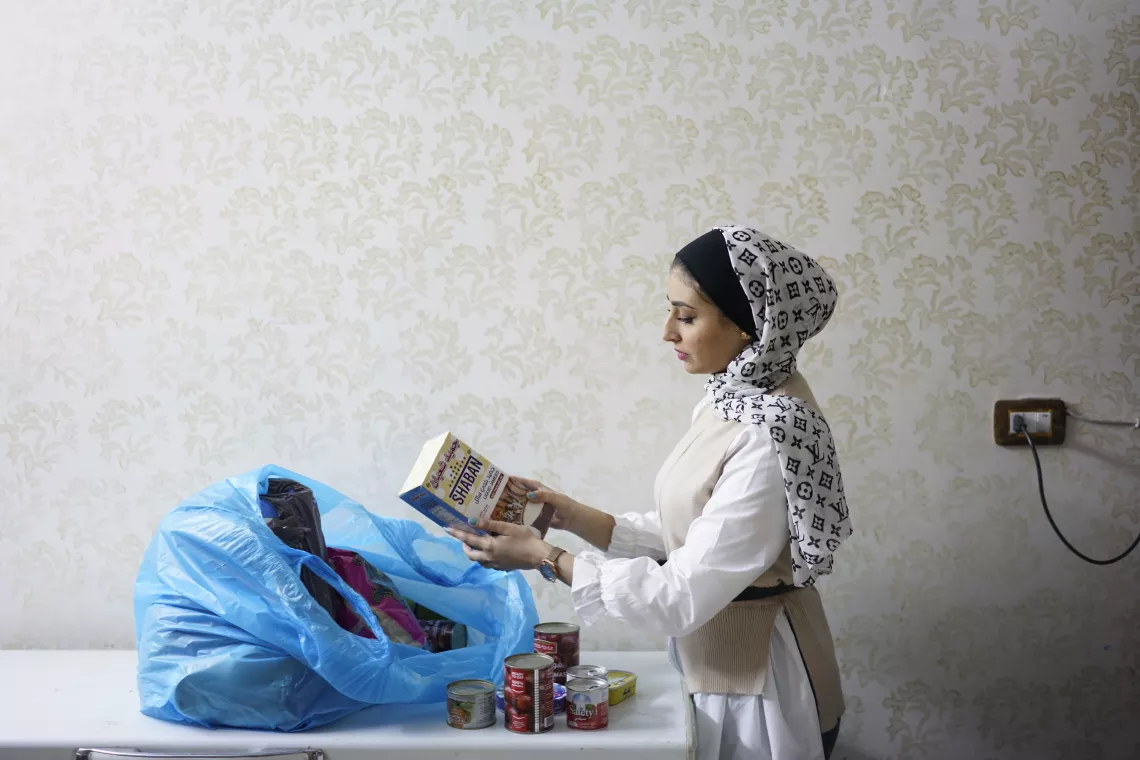 A young woman packs a food parcel 