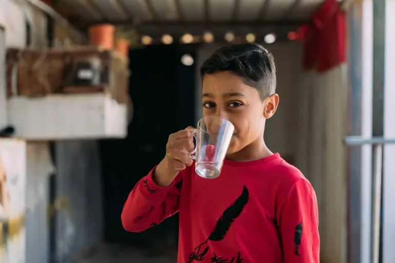 A boy drinks water. 