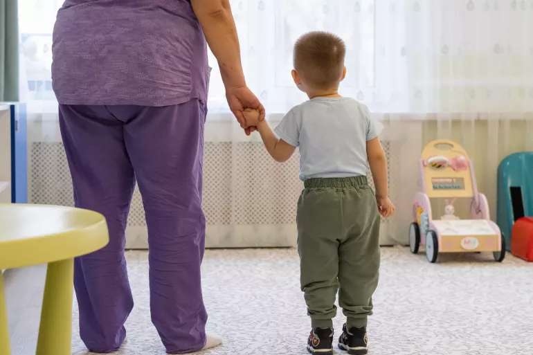 a boy holding hands with a woman