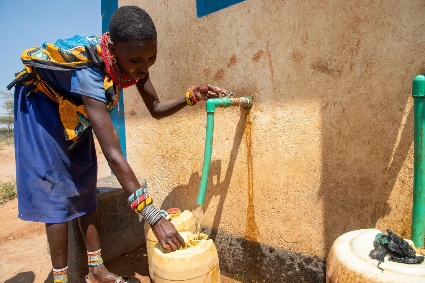  Naram fills her jerrycan at a water kiosk