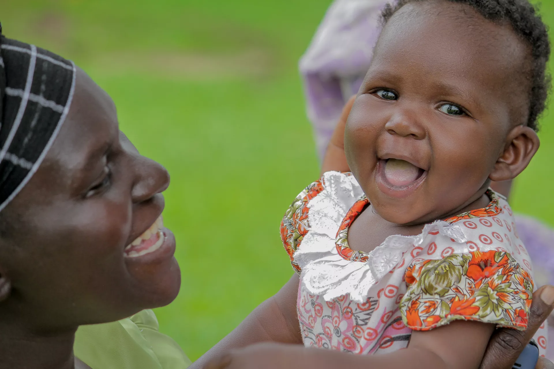 A mother plays with her daughter who is smiling.