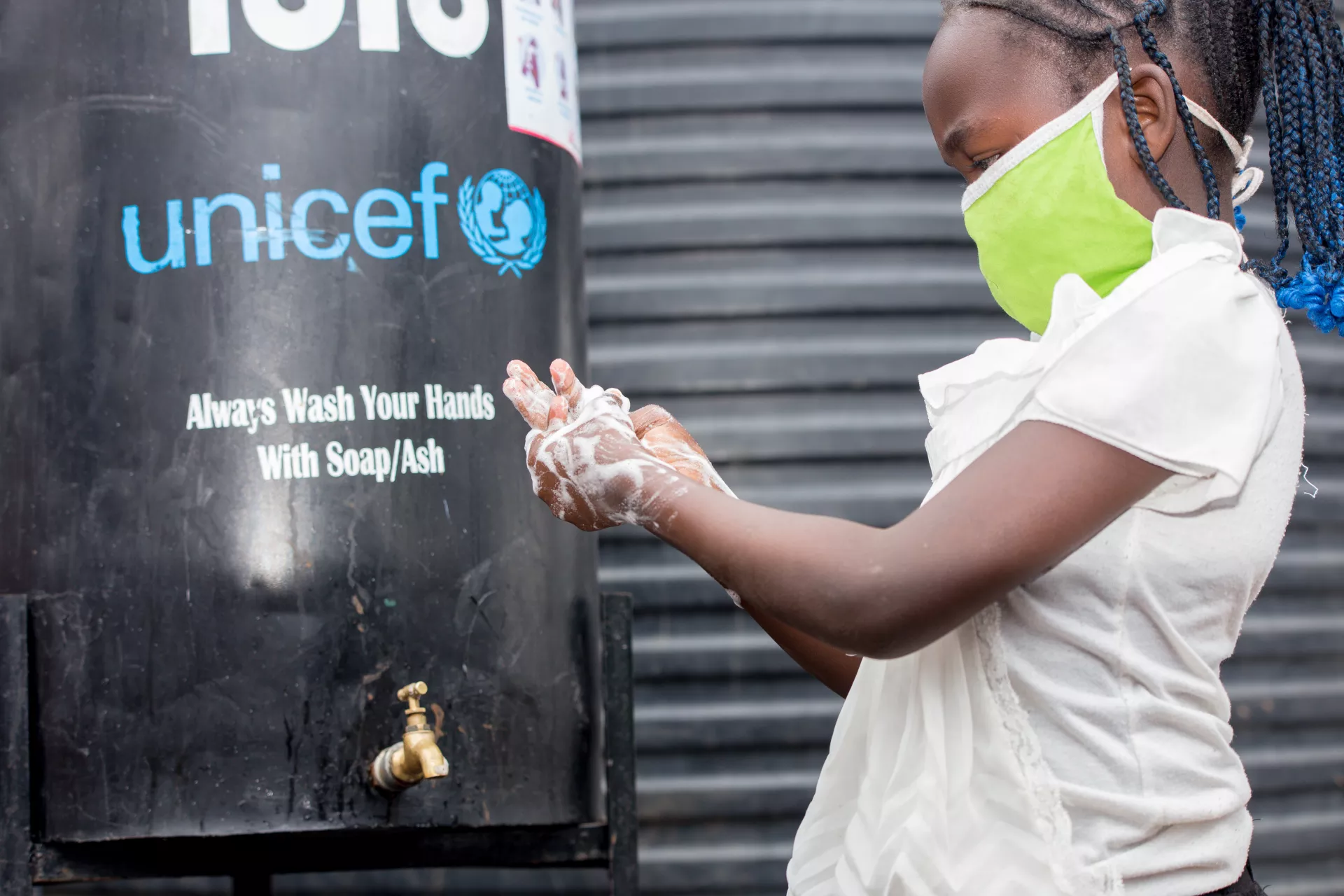 Girl washes hands in Mathare