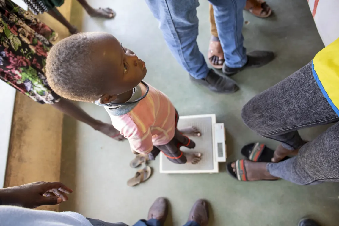 Melvin, 10, has her weight measured at Nakabosan Dispensary in Turkana County. 