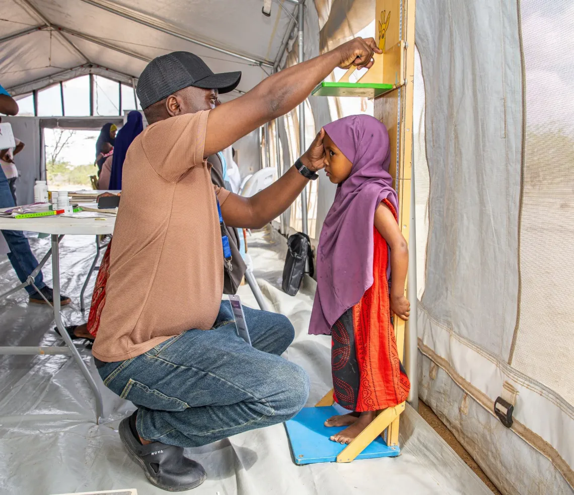 A health care worker screens 3-year-old Zamzam at the Abaqdera outreach site in Garissa County, Kenya 