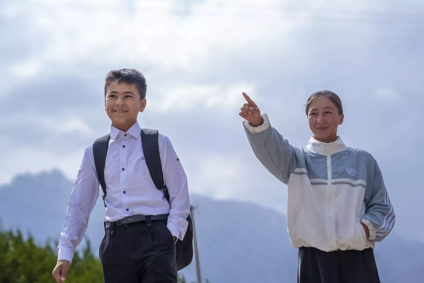 a boy and girl walking in the street together