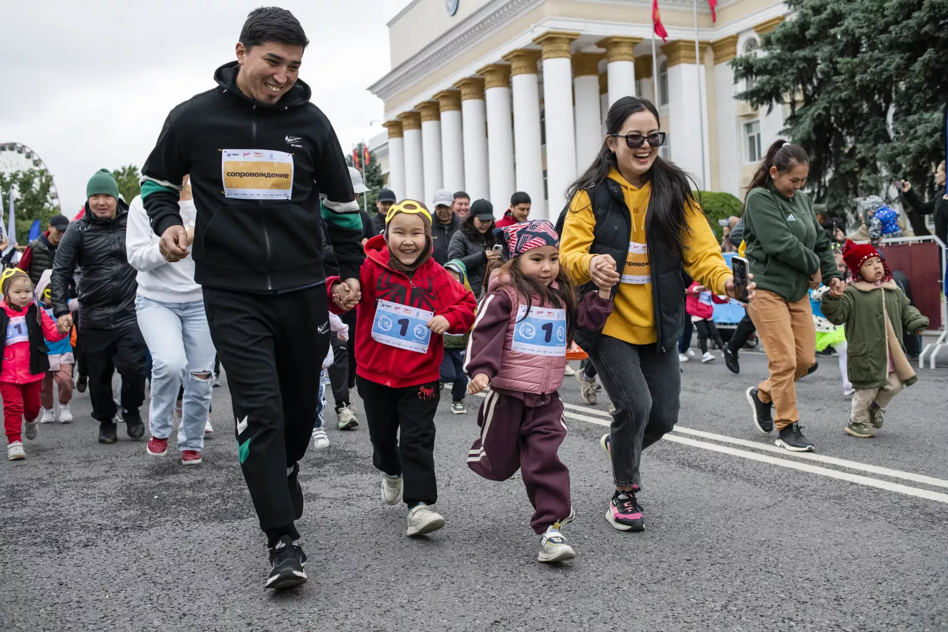 mother and father running together with their daughter and son