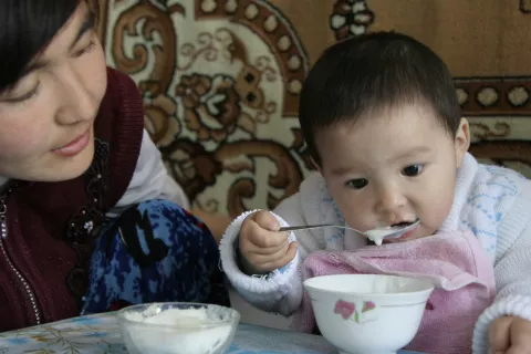 a child eats with his mother