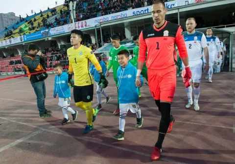Footballers walk onto field holding hands with children in UNICEF sweatshirts