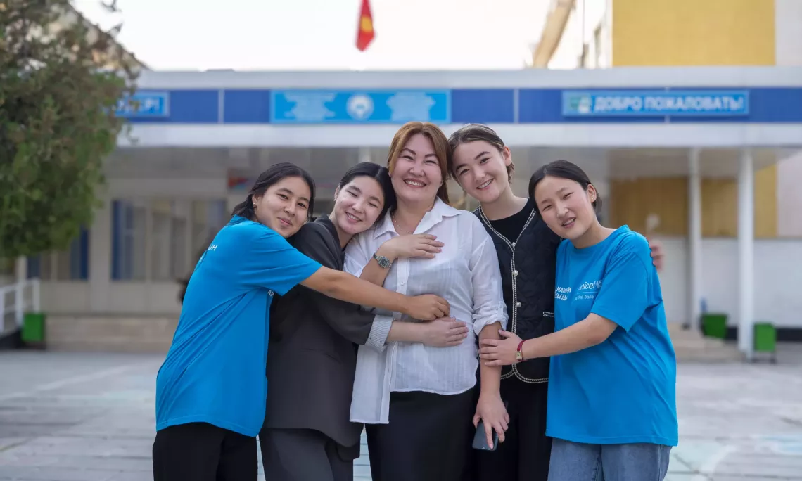 schoolgirls with their teacher in front of a school