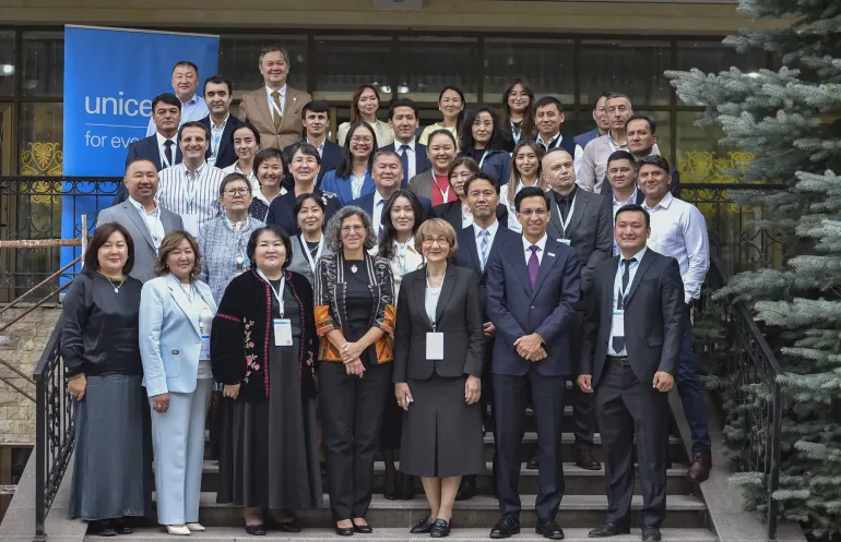 A group photo from the event with all participants with UNICEF banner on the background