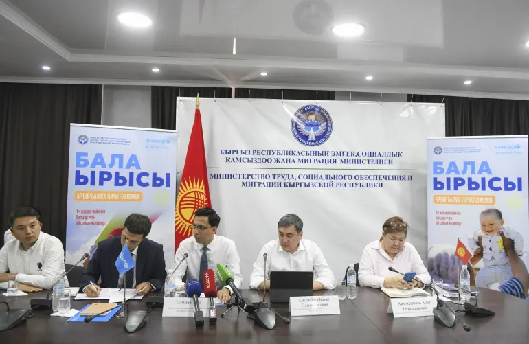 A photo with five people sitting on the table during the press conference
