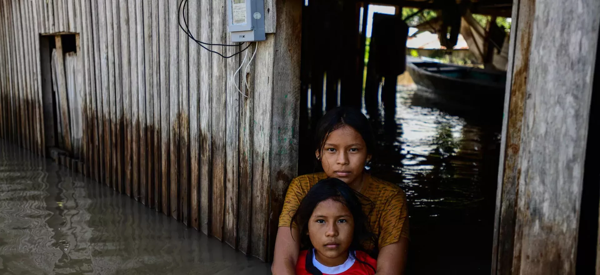 Dos ni&ntilde;as en una casa inundada en Per&uacute;