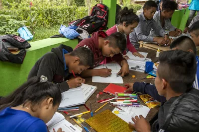 Jovenes escribiendo y coloreando en sus cuadernos 