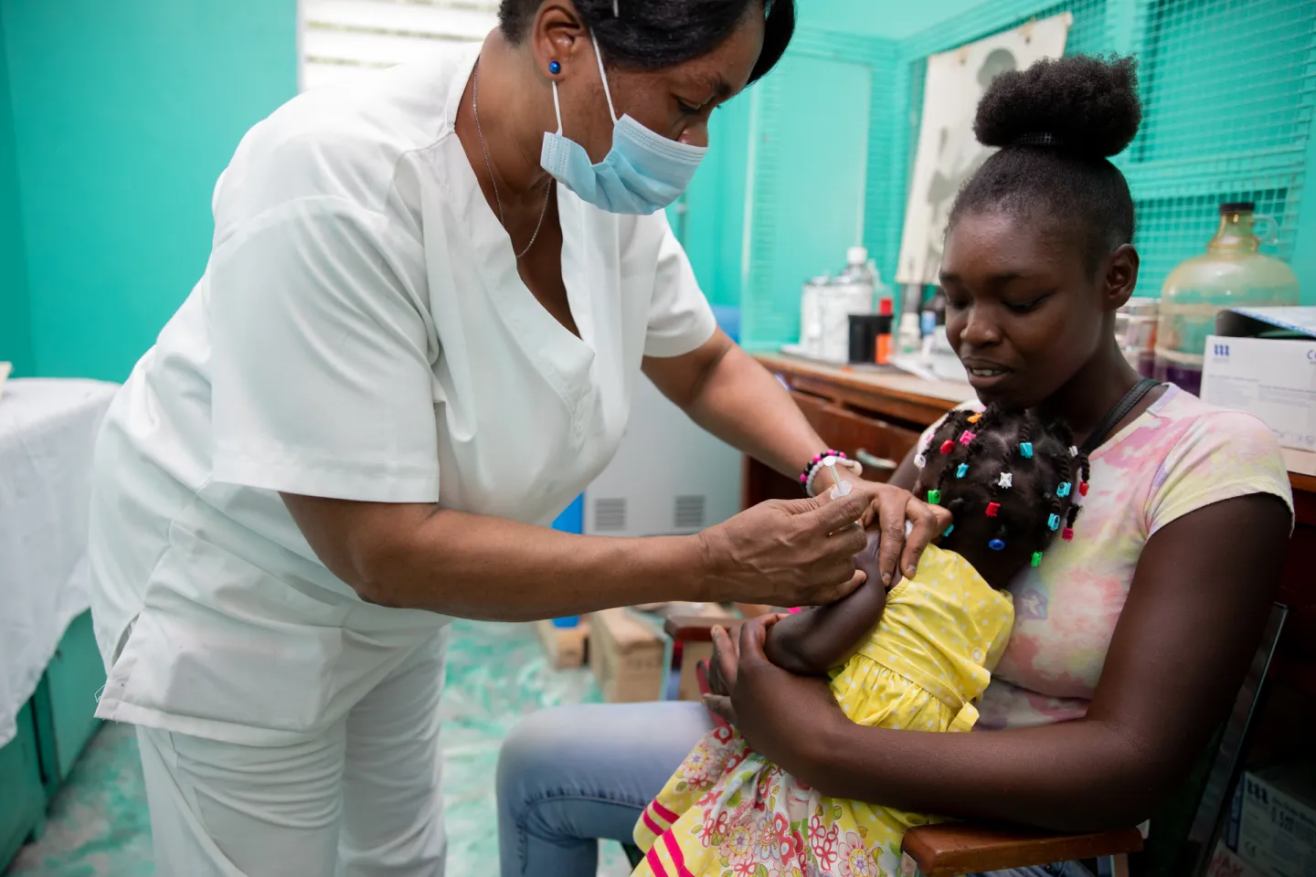 in Les Cayes, Haiti, Rosemirlande, 27, holds her six-month-old son, Jamesly, during a visit to Sacre Couer Health Centre for him to receive his routine immunizations. 