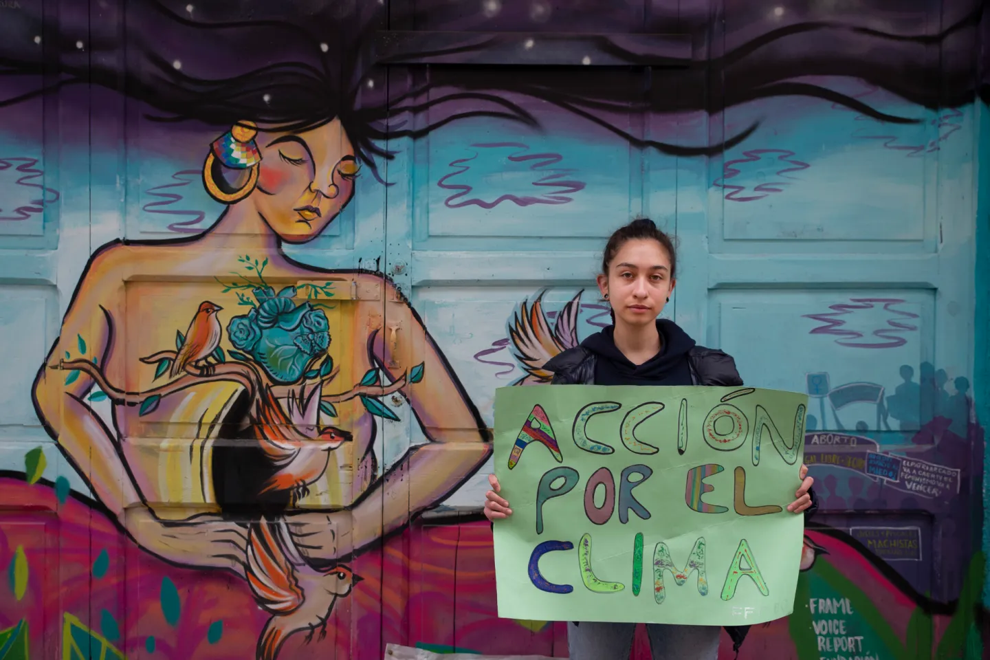 Una joven activista sostiene un letrero que dice: Acci&oacute;n por el clima.