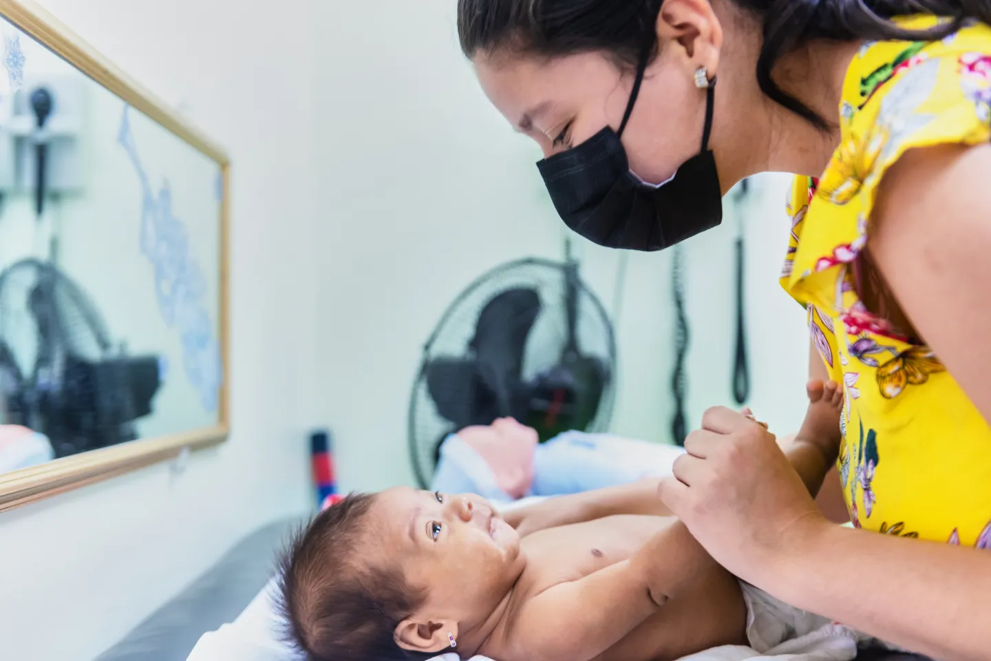 Una madre interact&uacute;a con su hija durante una visita al pediatra.