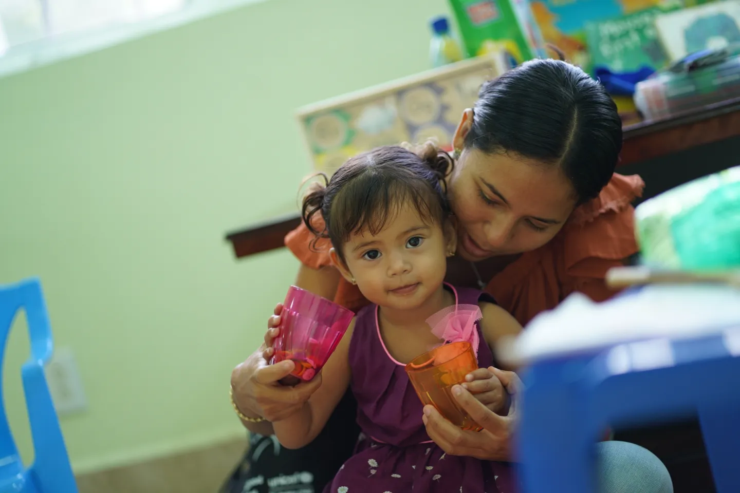 Una ni&ntilde;a y su madre en Belmopan, Belice, asisten a un examen m&eacute;dico que incluye asesoramiento como parte del programa Care for Child Development.