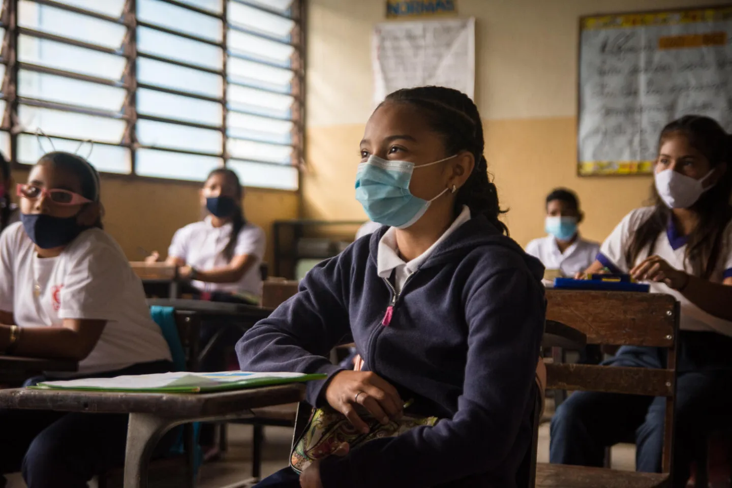 Ni&ntilde;os con mascarilla en una aula de clases.