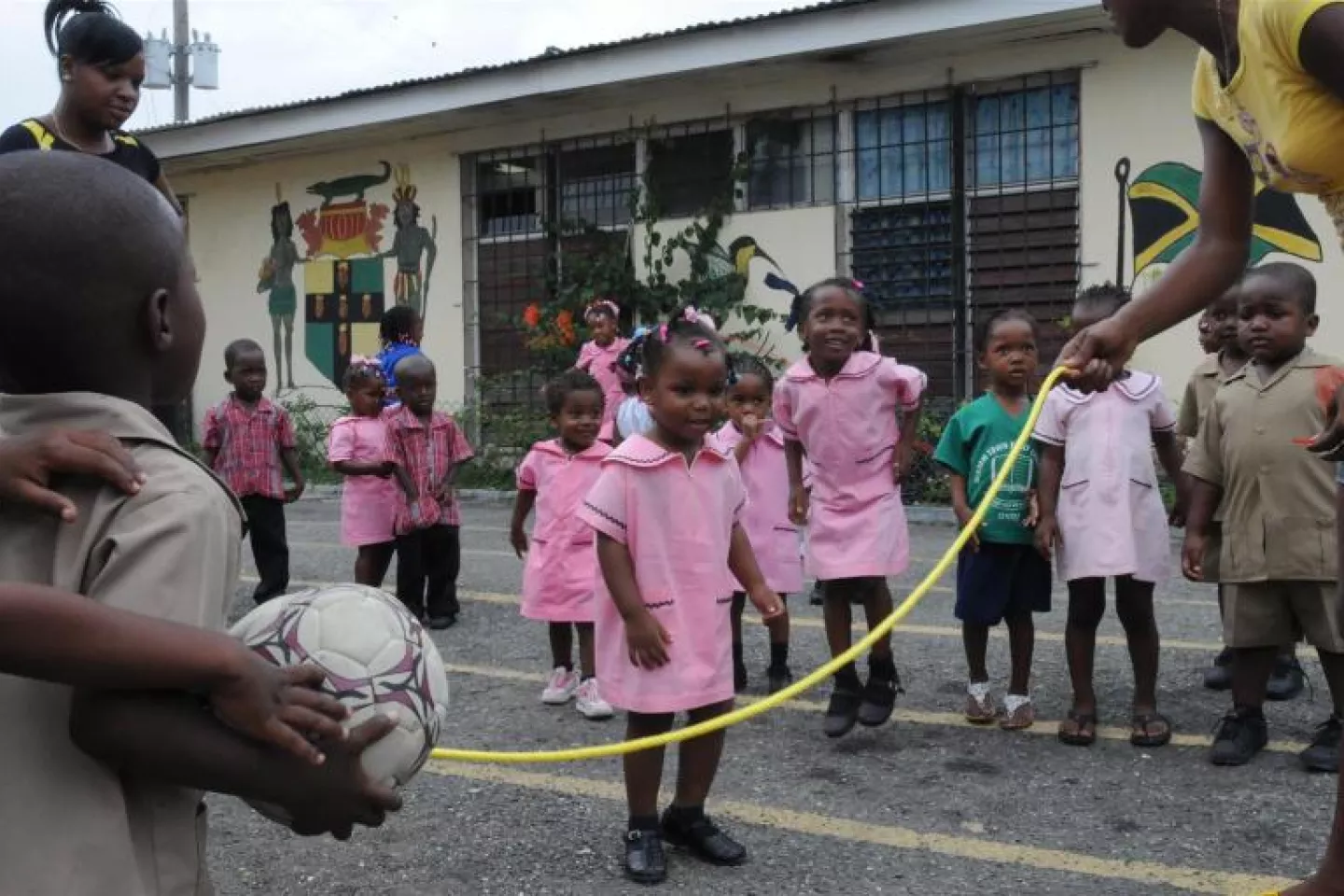 grupo de ni&ntilde;os y ni&ntilde;as jugando a saltar la cuerda.