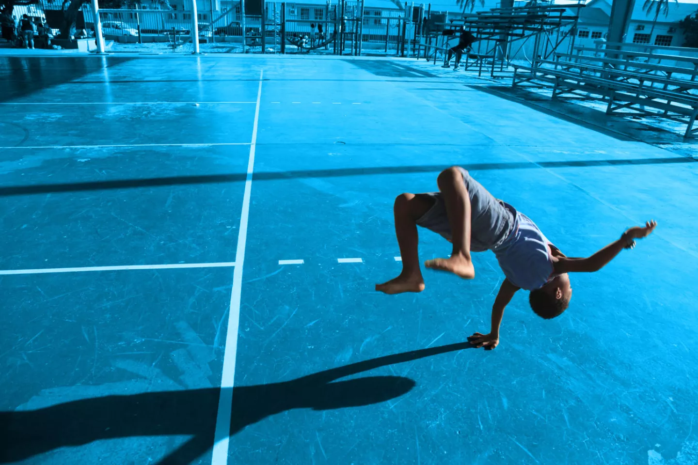 [TREATED PHOTO] A participant in a YMCA after-school programme performs backflips in an outdoor sports area, near the city of San Nicolas. The 22-year-old programme, which receives funding from the Government, currently serves 77 children aged 4&ndash;18, offering counselling and educational services, as well as hot meals.