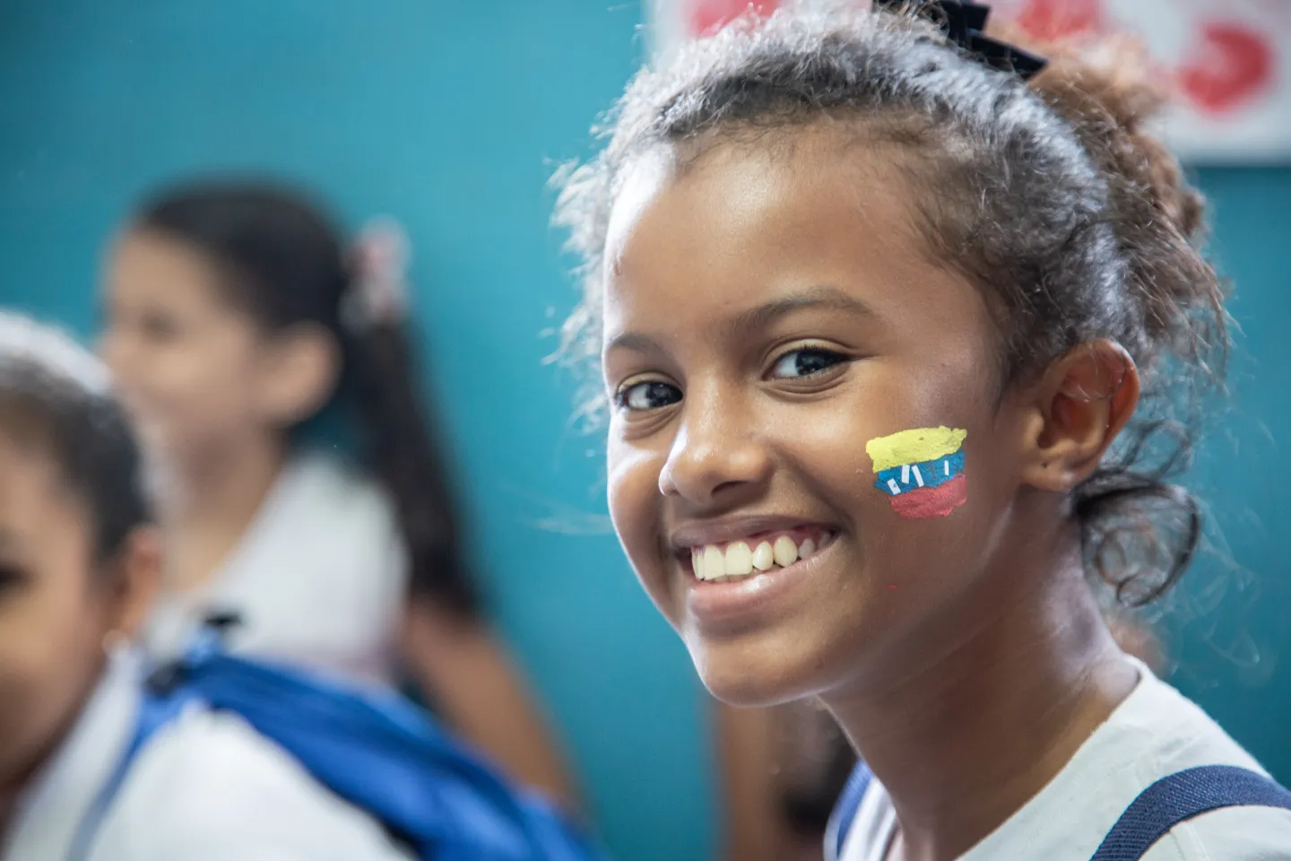 A girls with the Venezuelan flag painted in her face smiles during an art therapy activity in one of the protection centres supported by UNICEF, on July 17th 2019. Activities at the centre are part of the psychosocial support for the most vulnerable children and adolescents in Barrio Union, Petare, in the outskirts of Caracas, Venezuela. So far this year, UNICEF has provided psychosocial support for nearly 10,000 children and young people affected by the current economic crisis.