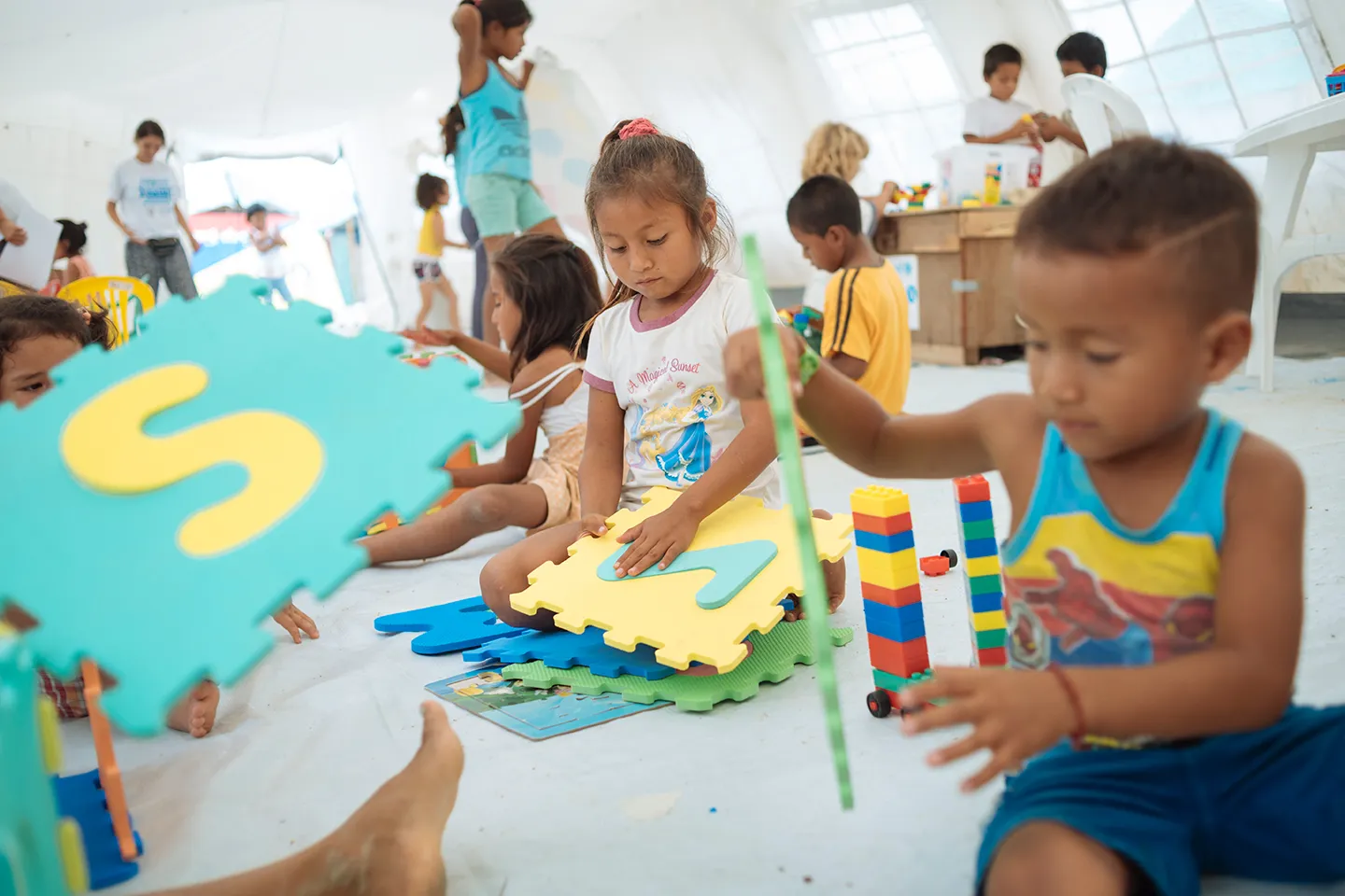 Ni&ntilde;os y ni&ntilde;as disfrutan de actividades l&uacute;dicas junto a miembros de Unicef en el Espacio Amigable para la Ni&ntilde;ez ubicado en el albergue Portete