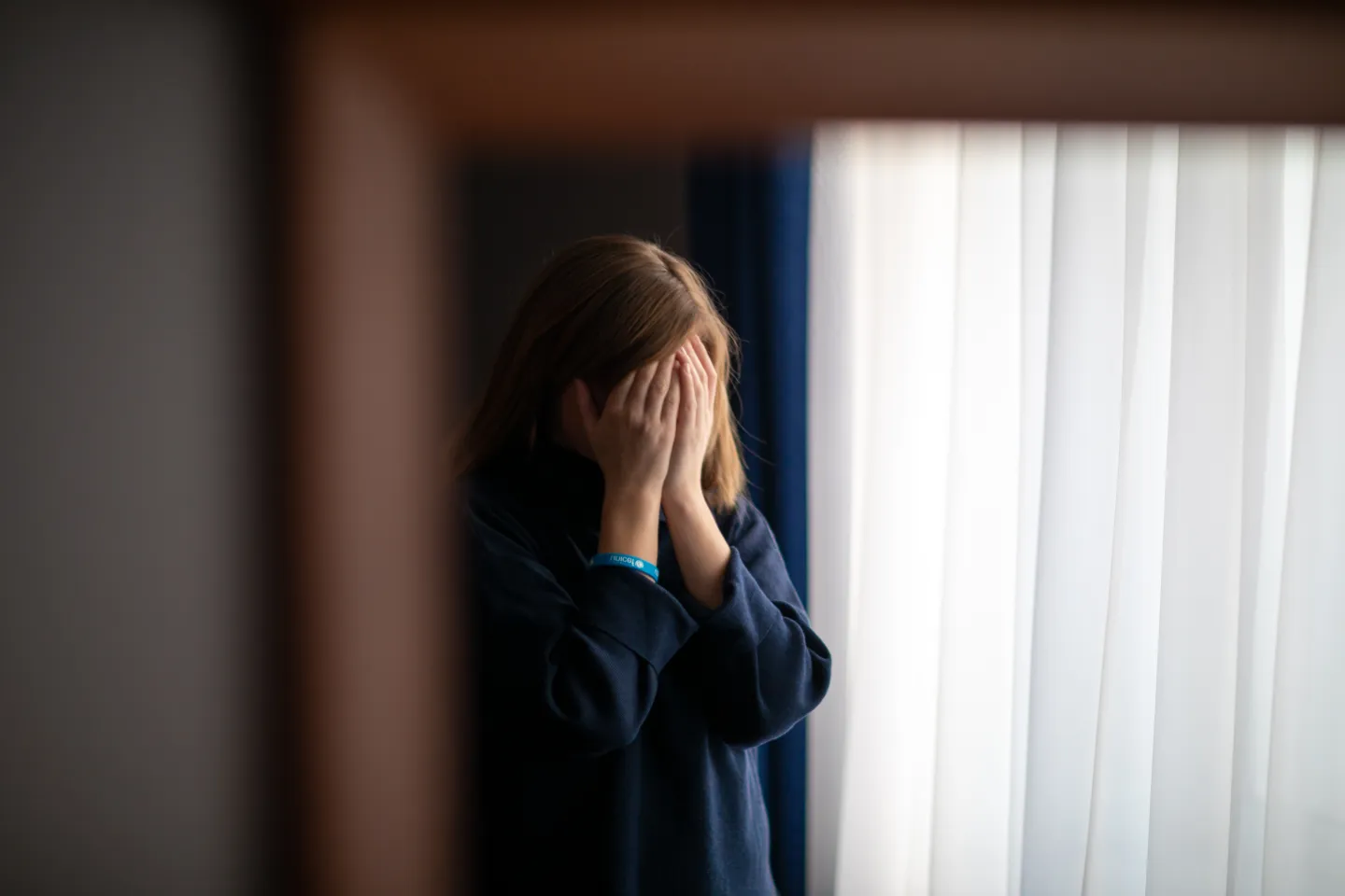 A girl holds her head in her hands