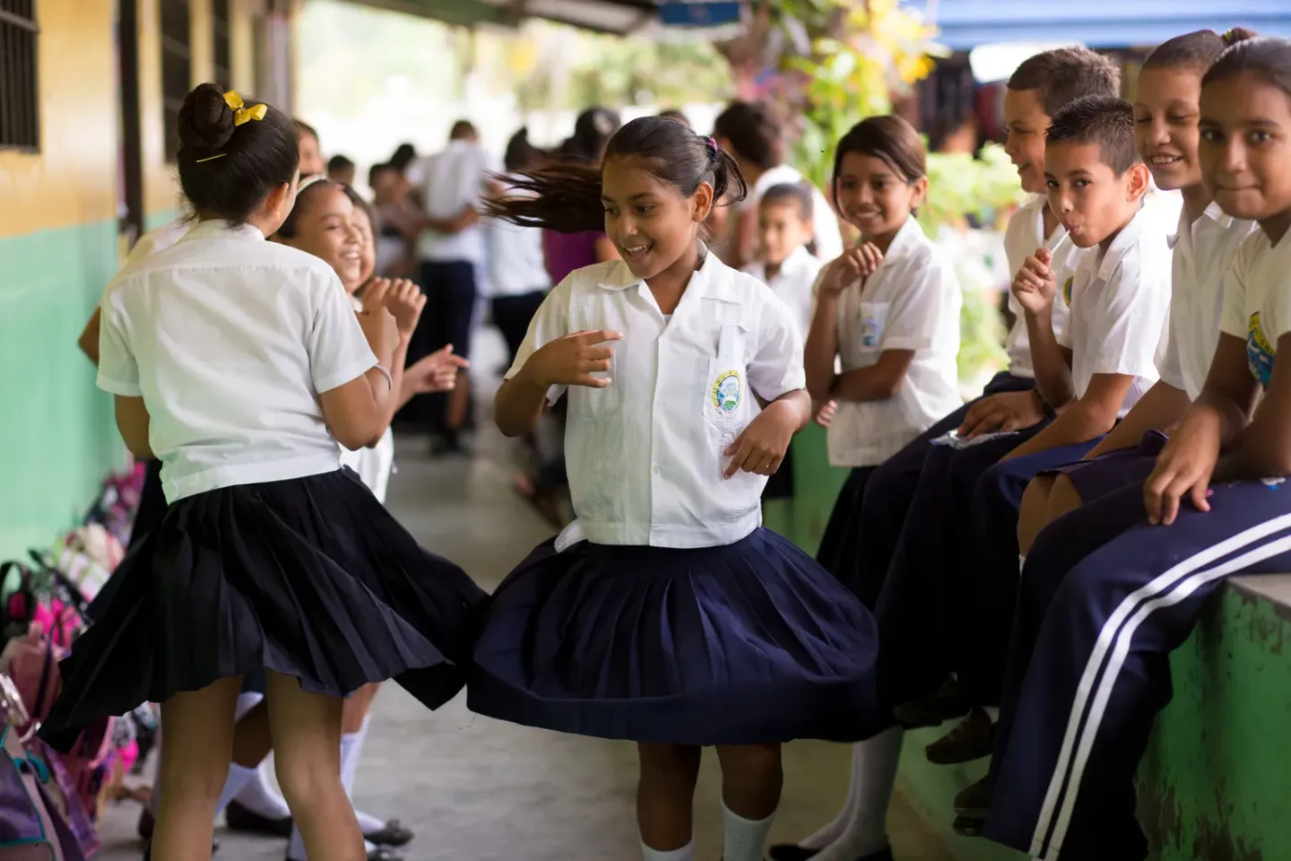 Ni&ntilde;os y ni&ntilde;as en uniforme afuera de un sal&oacute;n de clases