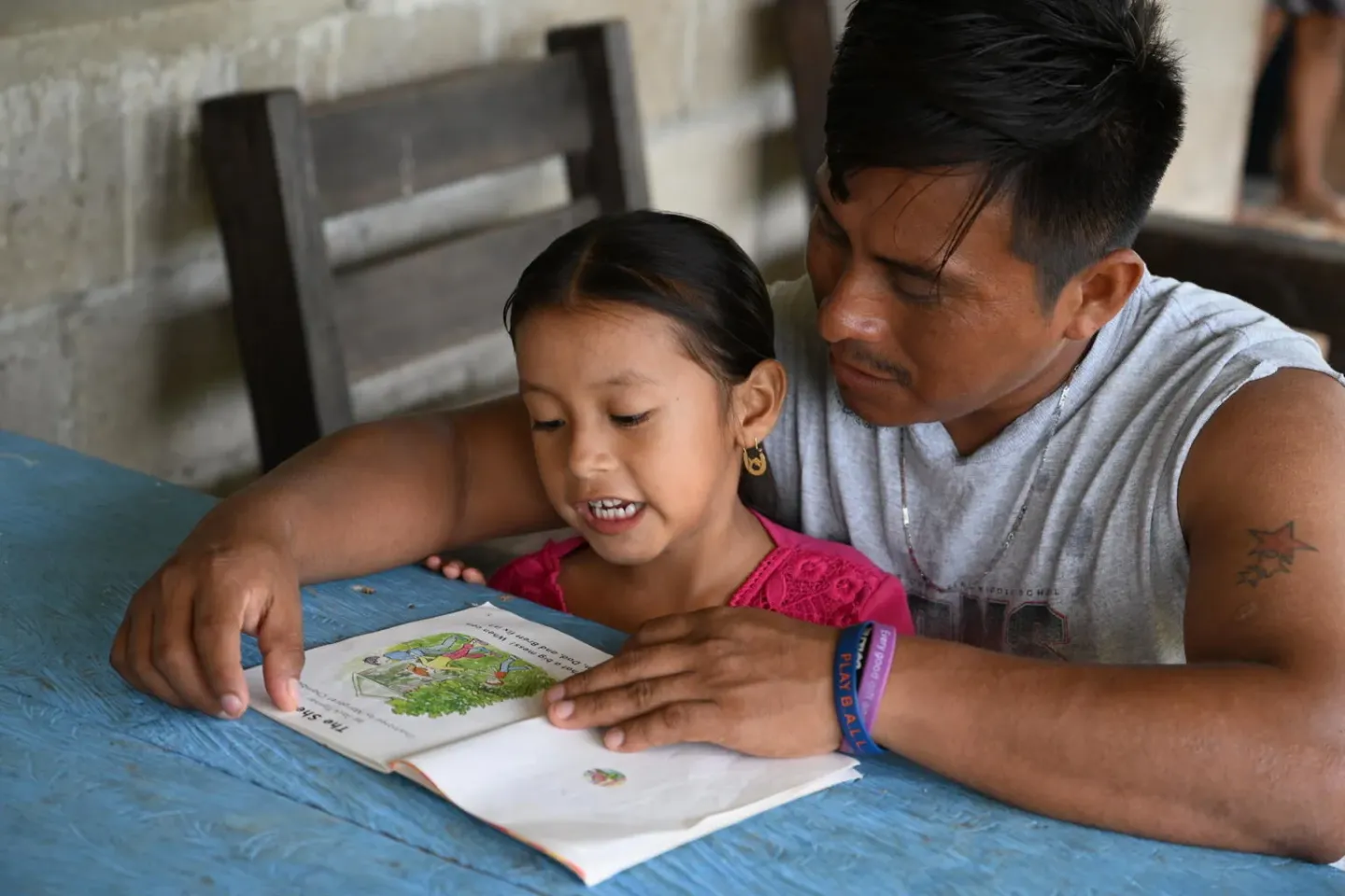Un hombre ayuda a una ni&ntilde;a a estudiar