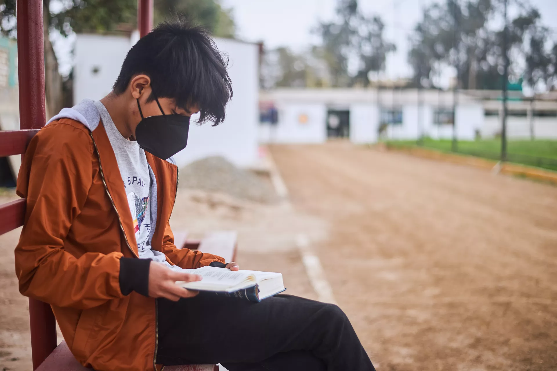 An adolescent boy reading a book.