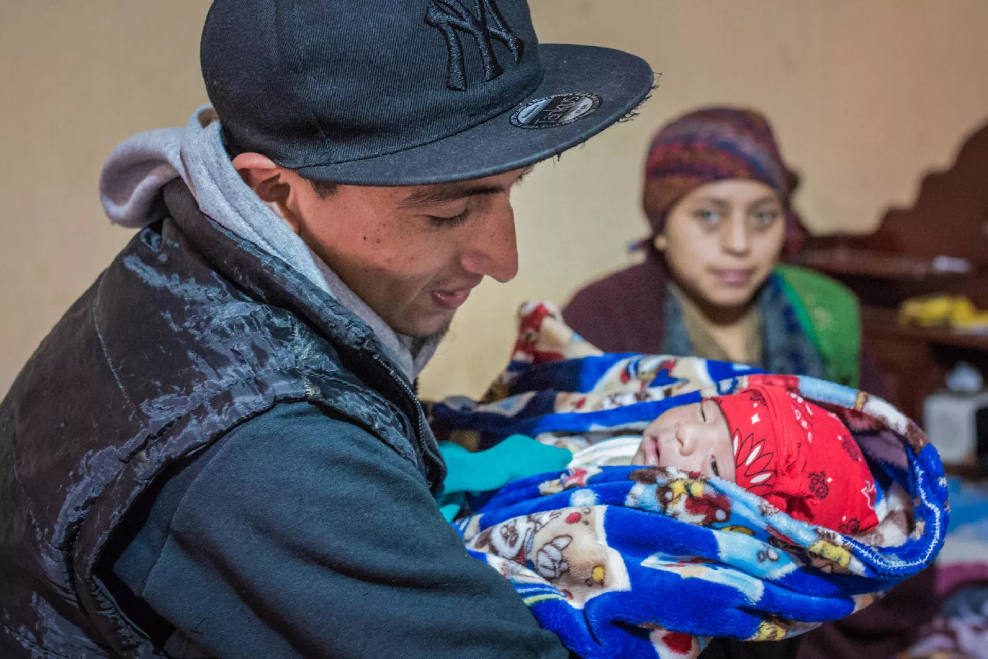 Un padre carga a su beb&eacute; de cuatro d&iacute;as de nacido.