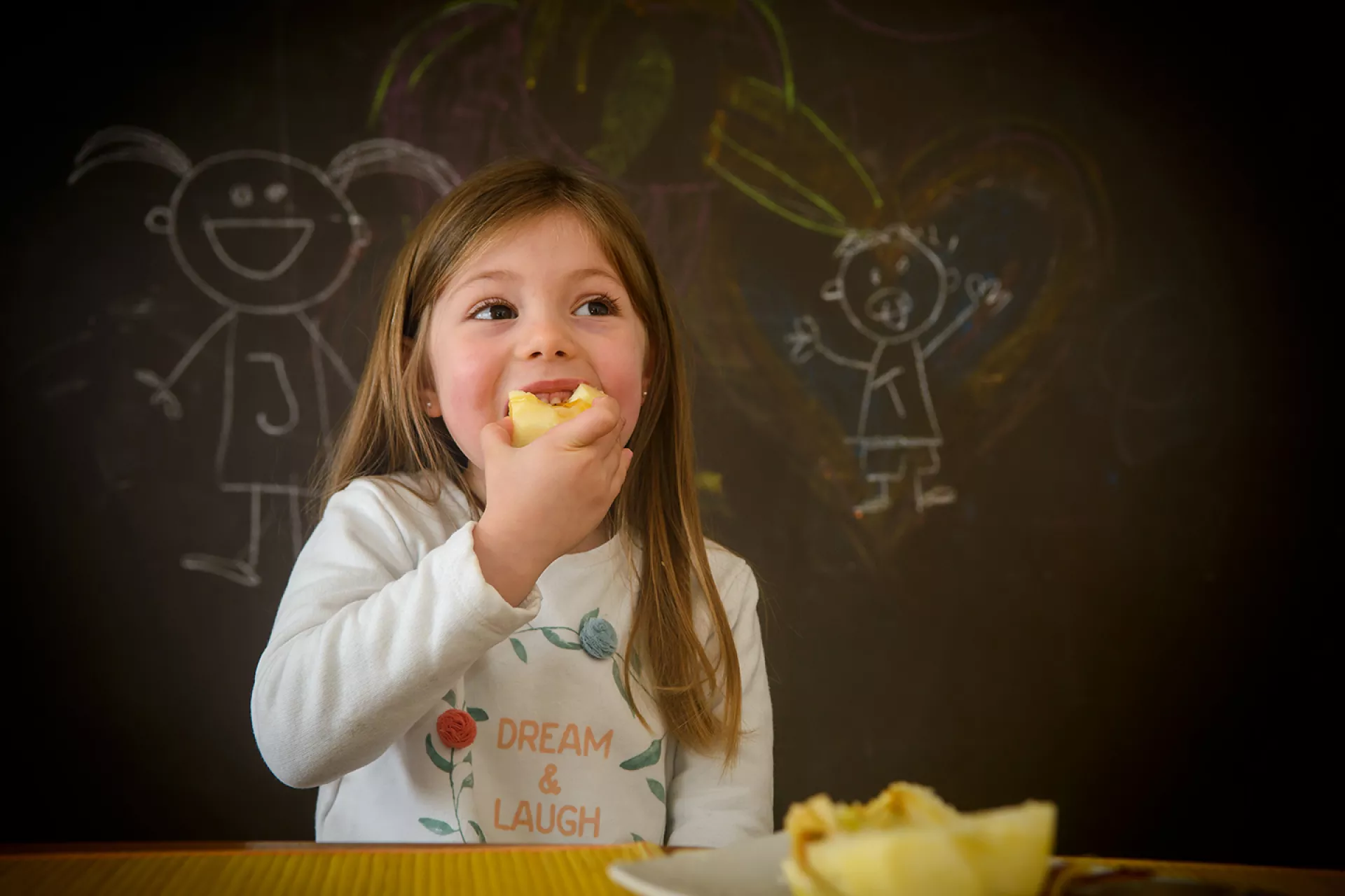 Jacinta, de 4 años, come una manzana en su casa de Montevideo, Uruguay. Los padres de Jacinta a menudo le dan fruta de postre. 