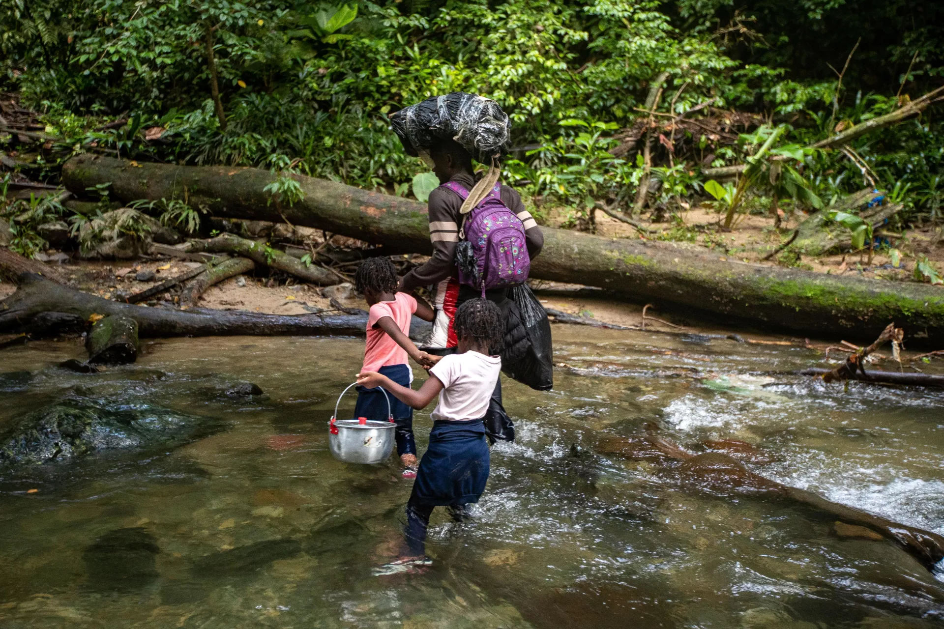 A father crosses the river with his two children on their way to the United States.