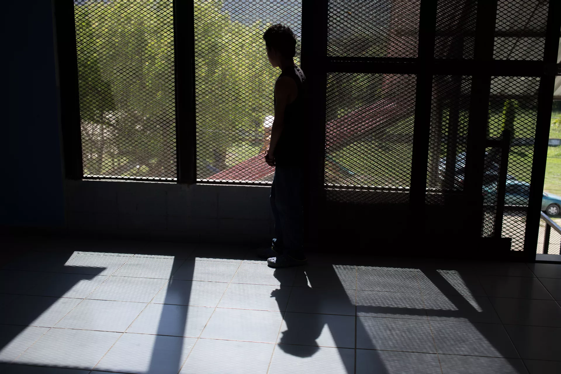 The figure of a teenager in the shadow.