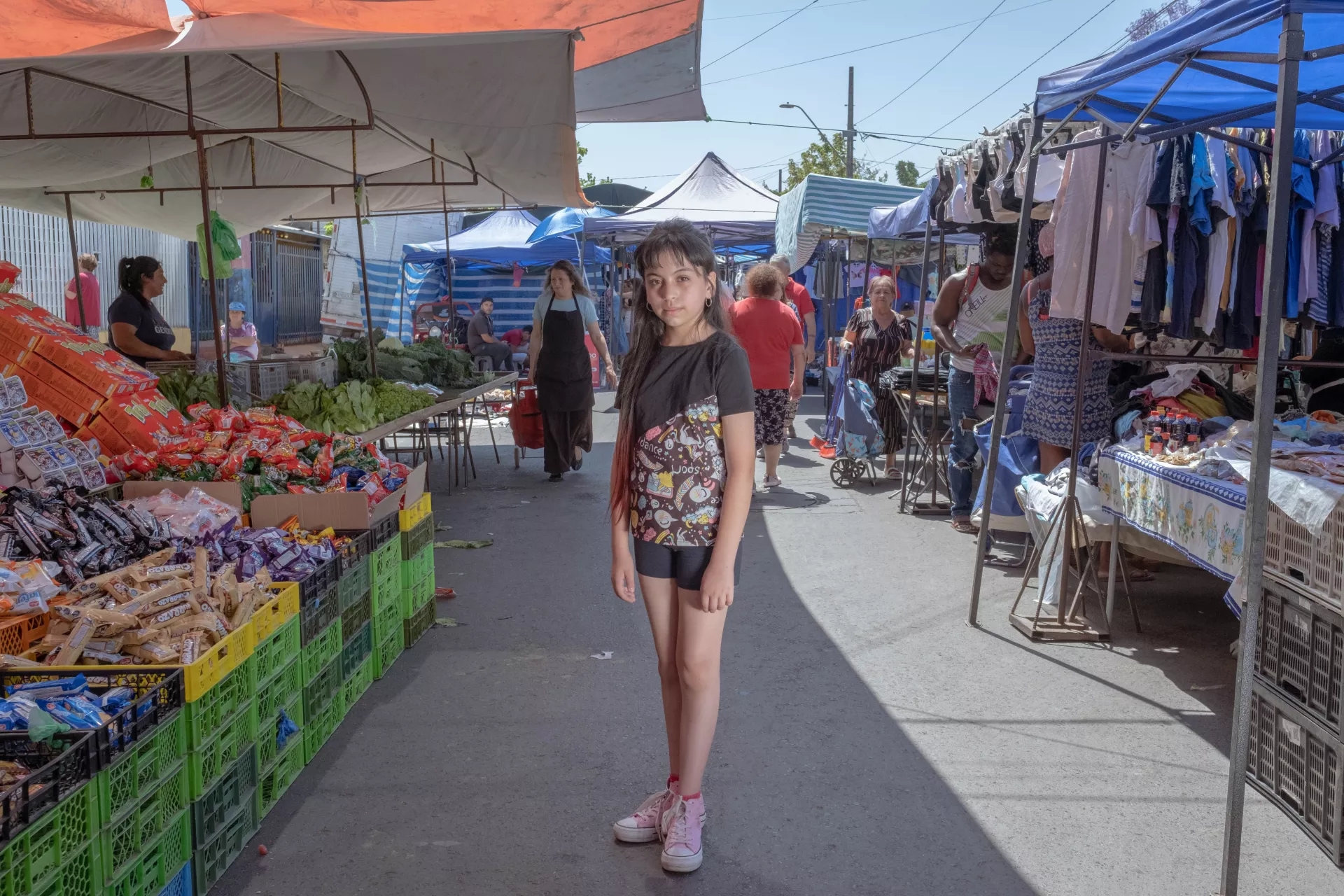 A girl stands for a portrait at a Saturday food fair in the La Pintana neighbourhood in the suburbs of Santiago, Chile. 
