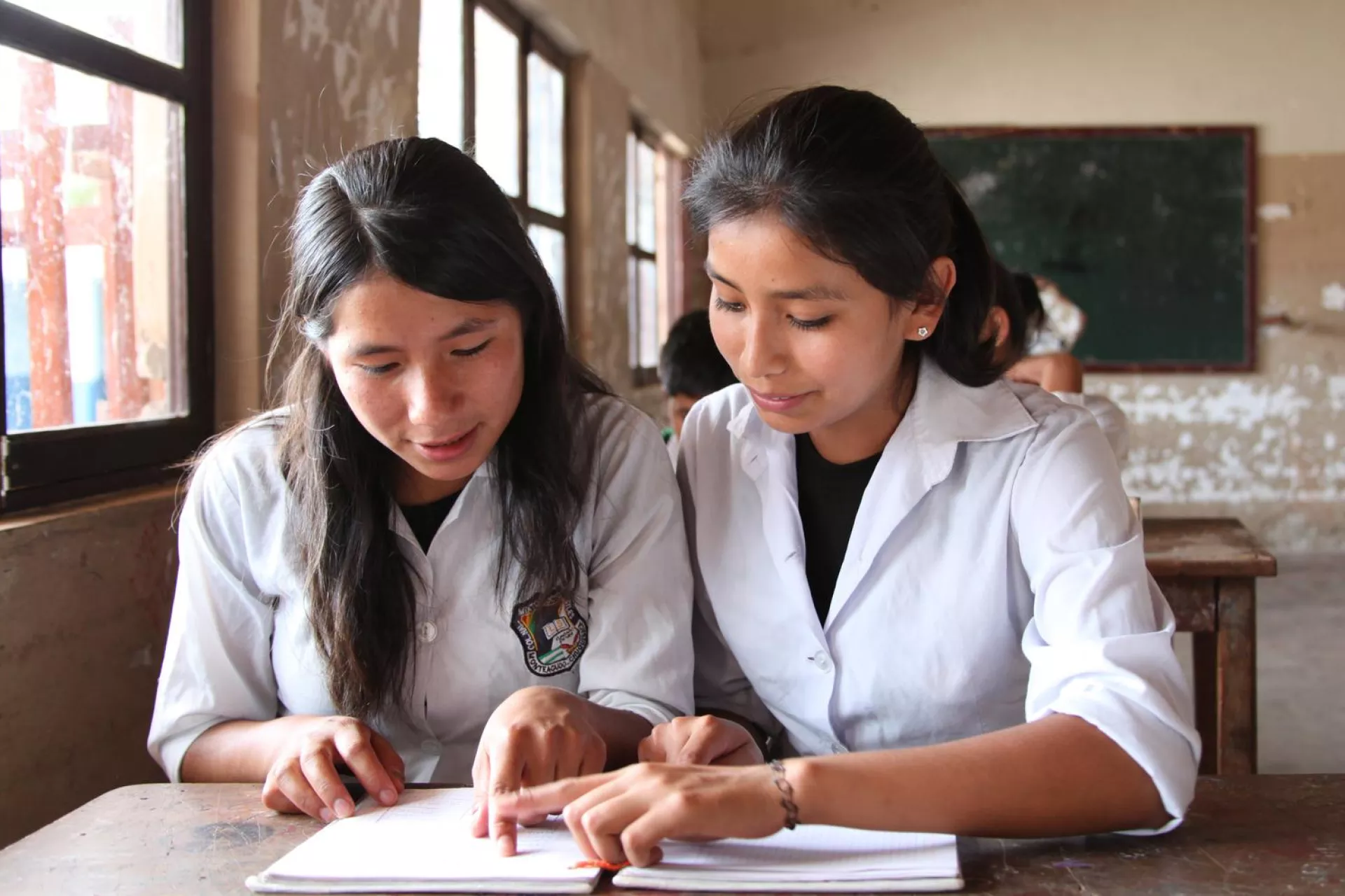 haceyda, 14, and her classmate Jacqueline, 13, read together during class, at Lucio Siles Morales High School in Monteagudo Town in Monteagudo Municipality, in the sparsely populated Chaco Boliviano region