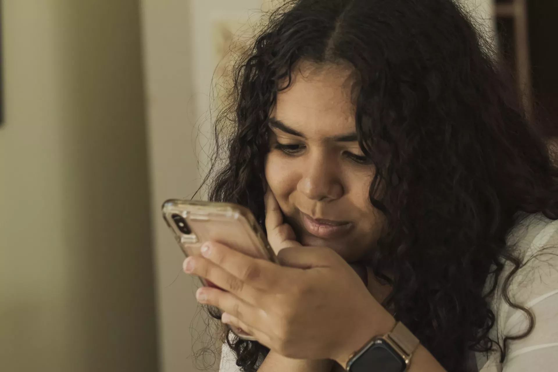 Una adolescente mira un celular 