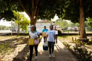 Three health workers carrying cooler boxes with vaccines.