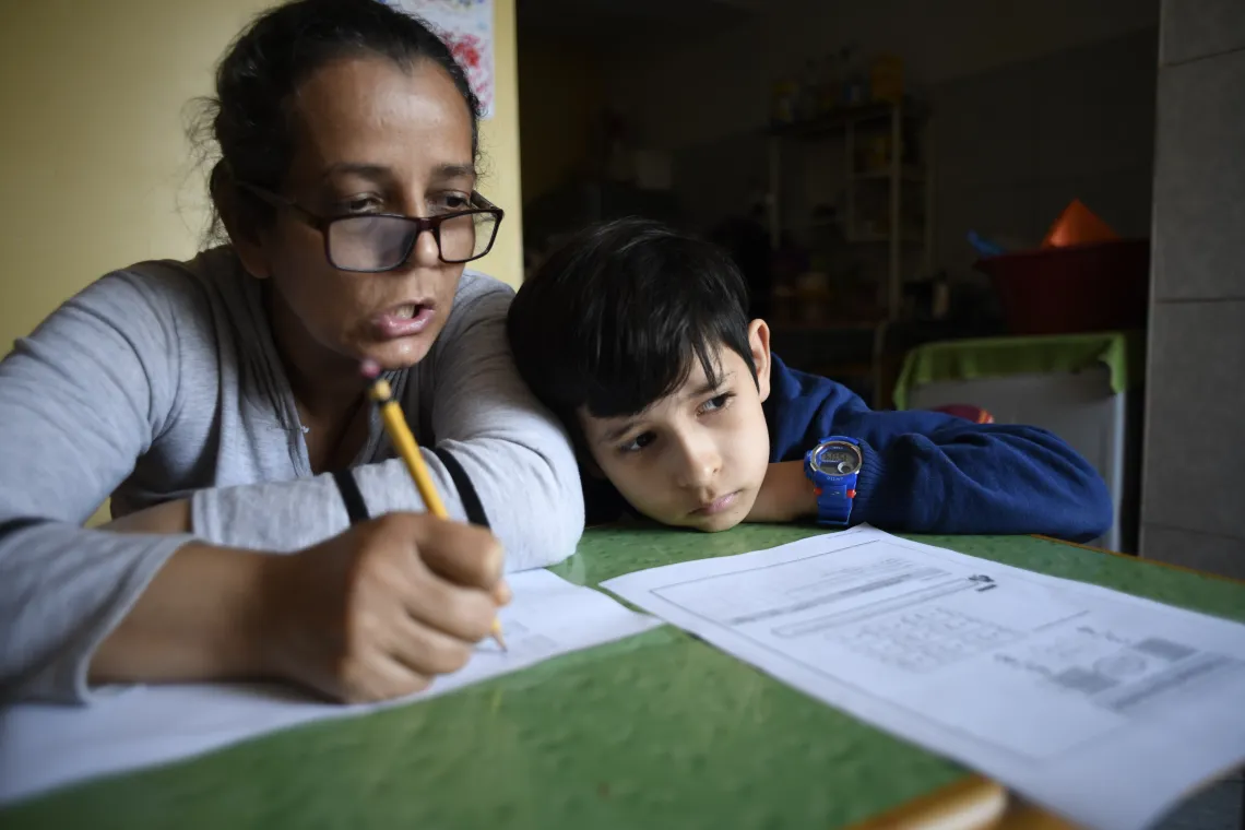 In&eacute;s Rosales helps her son Samuel (10) with the school homework at the small dwelling she occupies with her family in San Martin de Porres district in Lima, Per&uacute;, on september 23th, 2020.