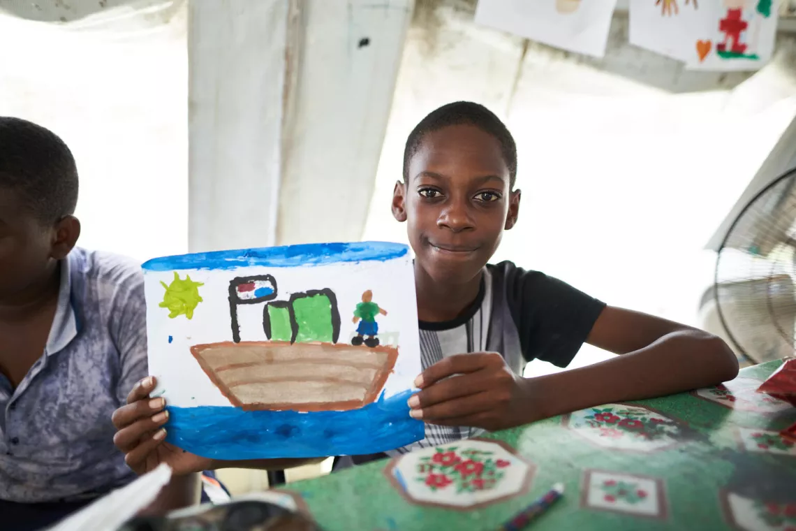 A boy shows his painting.