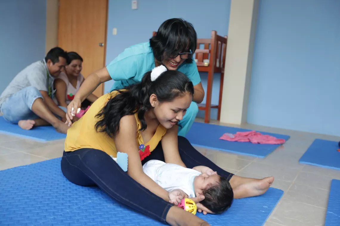  Bajo a atenta mirada de la especialista, una madre interact&uacute;a con su hija durante una vista al pediatra.