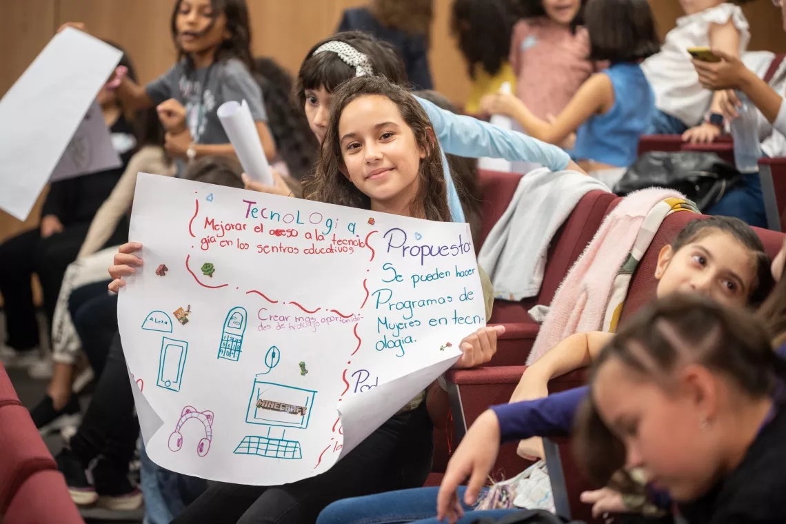 A girl holds up a banner about technology