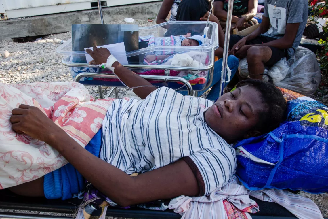 Clautine, accompanied by her 15-day-old son, waits for medical attention at Immaculee Conception Hospital
