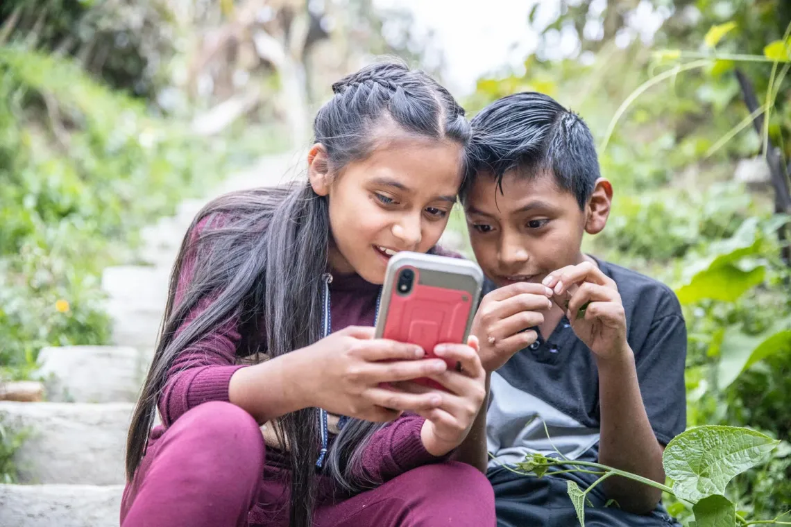 Dos ni&ntilde;os mirando un smartphone juntos