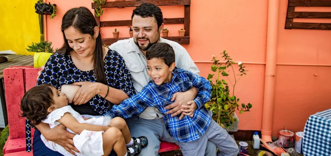 Una familia sentada junta mientras la madre da de lacctar