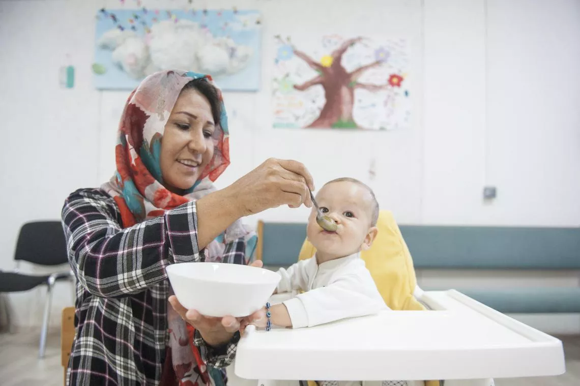 Refugee mother feeding her baby at ADRA community centre in Belgrade, Serbia.