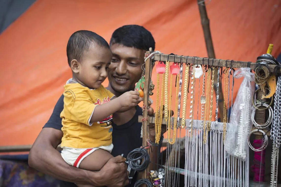Zakir smiles as he watches joy on his son's face in Dhaka, Bangladesh.